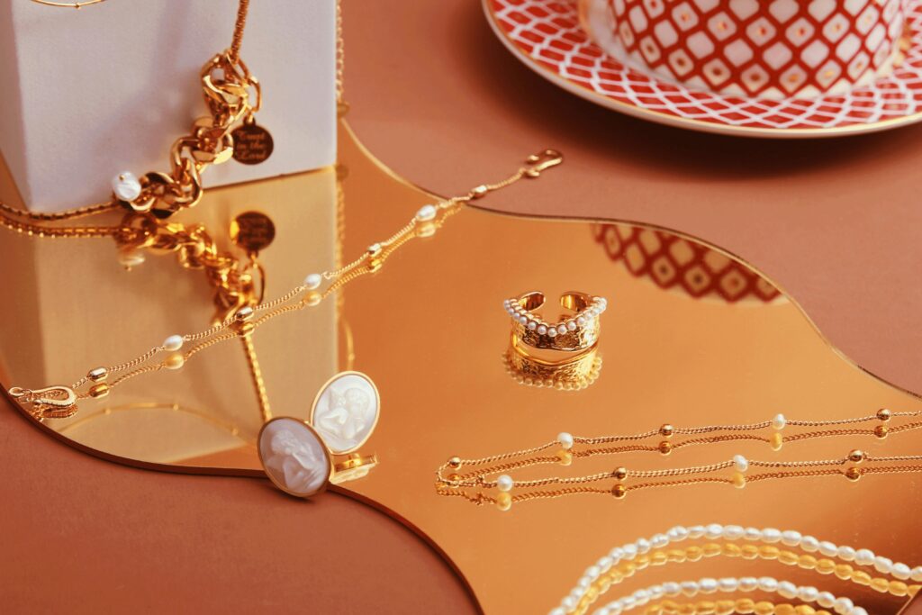 Stylish jewelry set elegantly displayed on a reflective gold tray with chic tableware.